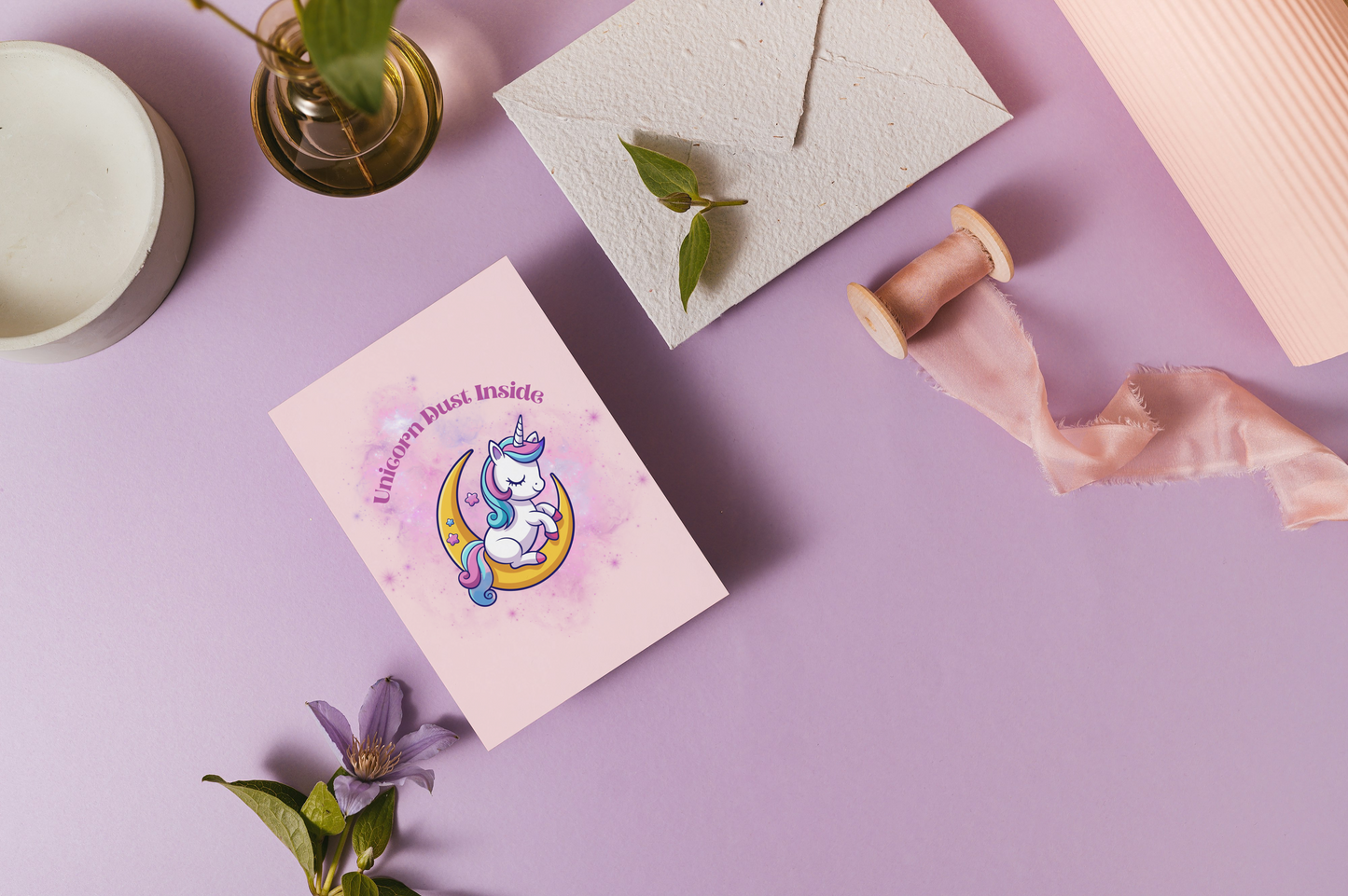Card with unicorn design on a purple surface with decorative elements