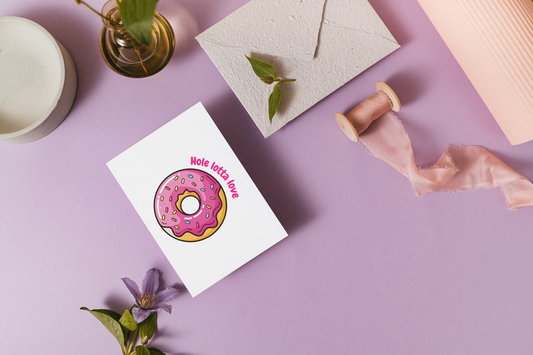 Greeting card with a donut design on a purple surface with decorative elements.