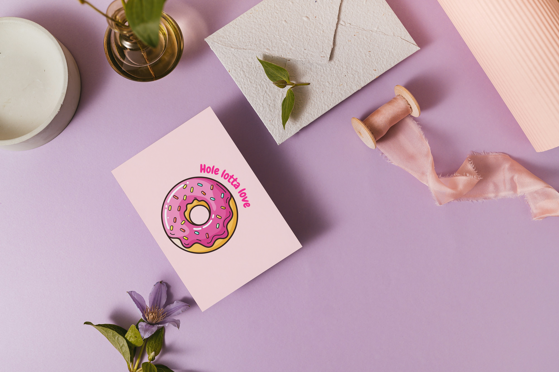 Greeting card with a donut design on a purple surface with decorative elements.