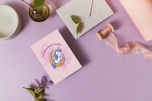 Card with unicorn design on a purple surface with decorative elements